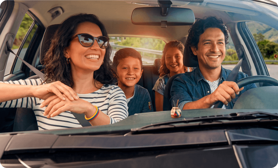 Familia feliz disfrutando de un viaje en carro, ilustrando las experiencias y consejos de movilidad que puedes descubrir en los artículos de nuestro blog sobre renting